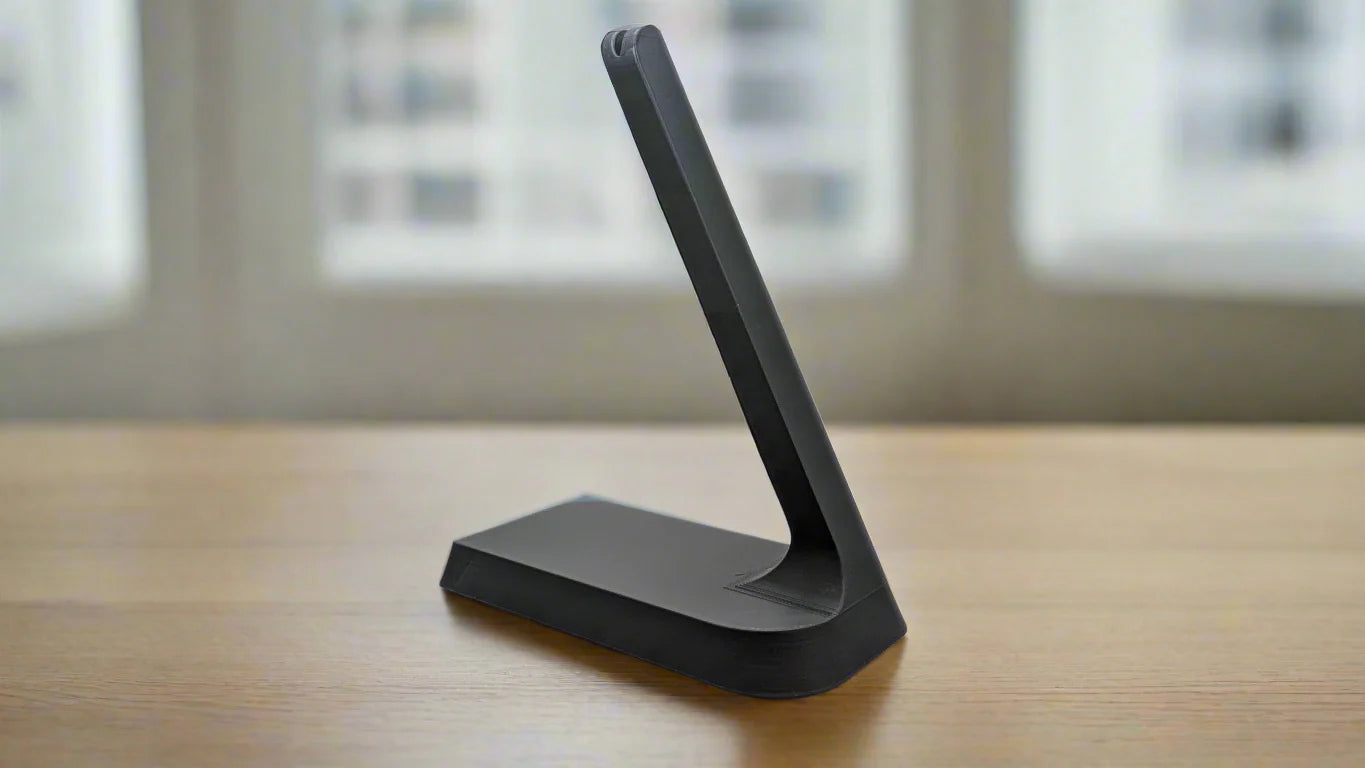 Grey headphone charging phone stand on a wood table top. Shokz bone conduction headphones.