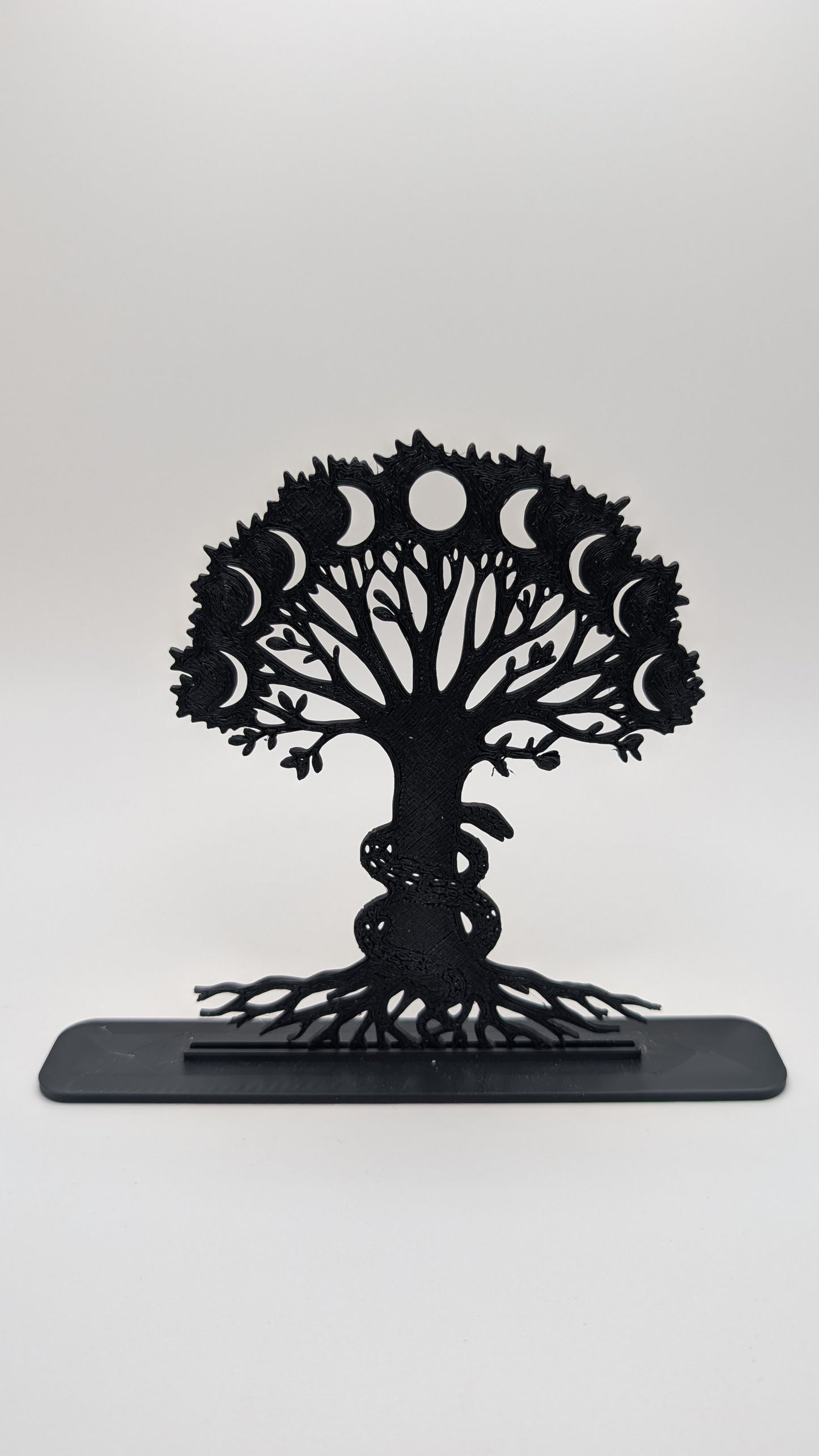 Intricate Tree of Life display piece with moon phase cutouts and coiled snake, made from black filament and shown on plain backdrop