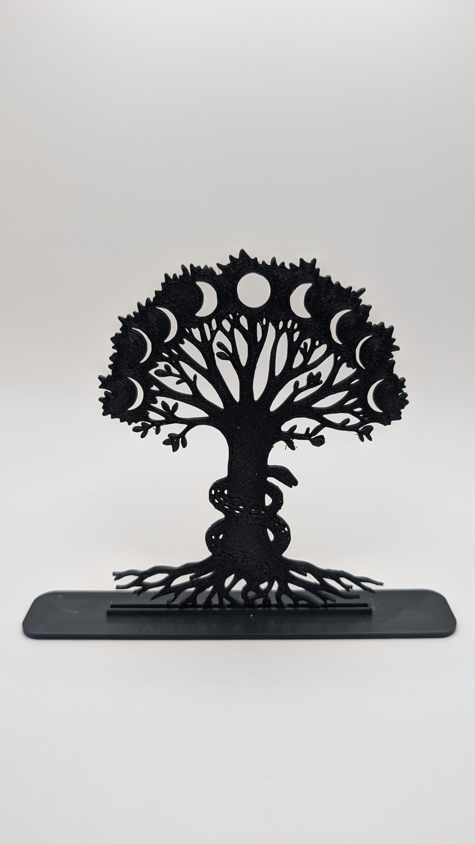 Intricate Tree of Life display piece with moon phase cutouts and coiled snake, made from black filament and shown on plain backdrop